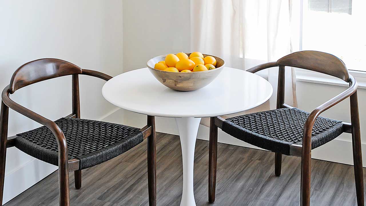 table and chairs with a bowl of oranges